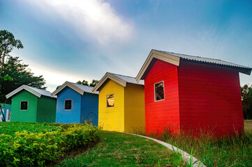 Colorful row of small houses in a vibrant outdoor setting, showcasing a playful and cheerful atmosphere. The scene captures the essence of a whimsical neighborhood and community.