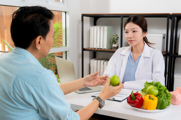 Asian nutritionist consulting patient in clinic, meal plan discussion, healthcare advice, weight loss support, doctor talking and explaining patient for nutrition consultation, wellness care.