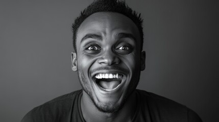 Black and white portrait of a man with an extremely happy expression and wide open mouth showing teeth and excitement