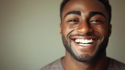 Close up portrait of a happy african american man with a beaming smile showcasing perfect teeth and positive emotion