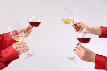 Women with glasses of wine on light background. Valentine's Day celebration