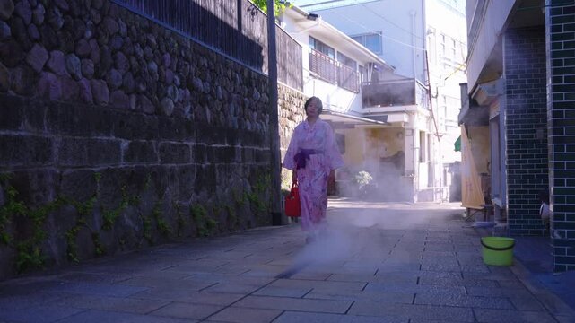 Japanese Girl in Pink Kimono Walking through Steam in Onsen Resort Town