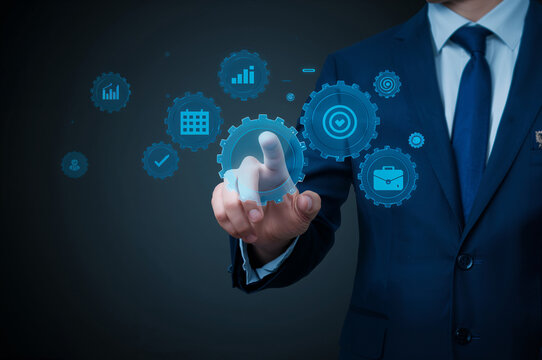 Businessman interacting with digital gears and icons representing business processes suit hand - Powered by Adobe