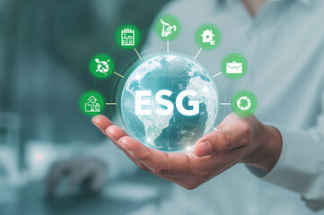 Fototapeta premium Person holding glowing globe with E S G text and green icons around it earth world