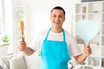 Male janitor with brush and dustpan in room