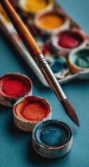 Close-up of paintbrush and watercolor paints