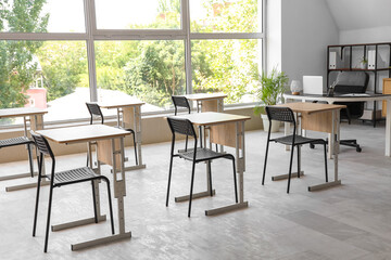 Desks and chairs in modern empty classroom