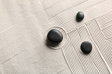 Black stones on light sand with lines. Zen concept