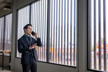 Asian businessman talking on phone in modern office building
