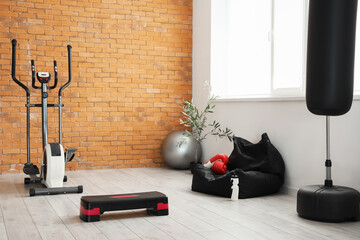Interior of gym with sports equipment and exercising bike