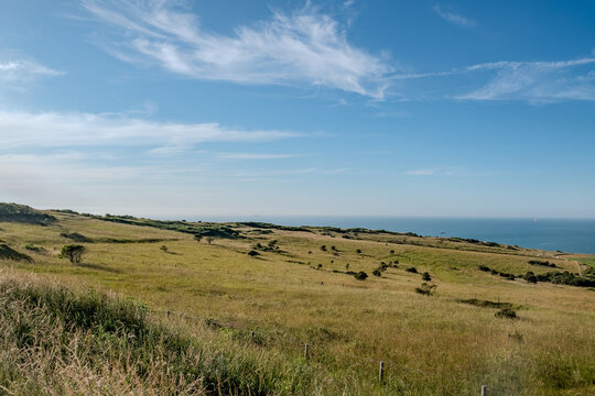 Cap Blanc-Nez, Escalles, Pas-de-Calais, Hauts-de-France, France, July 29th, 2025, A tranquil view of gently rolling hills where they beautifully meet the vast ocean under a clear blue sky