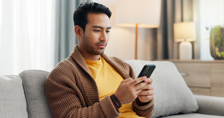 Phone, reading and relax with man on sofa in living room of home for social media scrolling. App,...