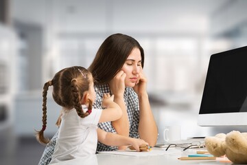 Happy busy mother working with a child on computer