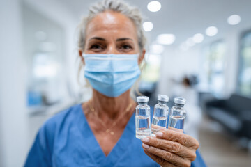 Fototapeta premium A nurse holding vaccine vials in a modern clinic