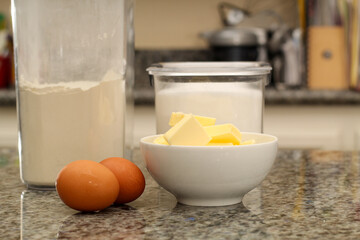 Eggs, Flour, and Butter Ingredients for Baking on Kitchen Countertop