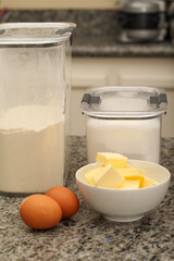 Eggs, Flour, and Butter Ingredients for Baking on Kitchen Countertop
