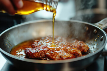 olive oil is poured onto a piece of meat while frying