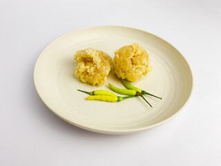 Cireng is a traditional street food snack from West Java, made from tapioca flour, water, and choppes green onion. Served with green chilies on round plate, isolated on white background.