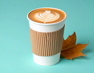 Paper coffee cup with cardboard sleeve and autumn leaves on blue background
