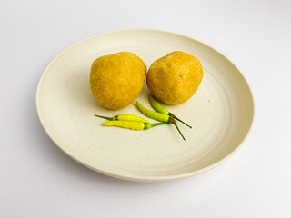 Tahu bulat is round tofu, snack made from soybeans, served with green chilies on a round plate. Indonesian food.