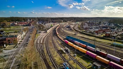 Fotobehang Spoorlijn Railroad, train tracks and trains aerial drone view from above, railway station in the Netherlands, transportation, logistics and public transport infrastructure concept  © Iuliia Sokolovska