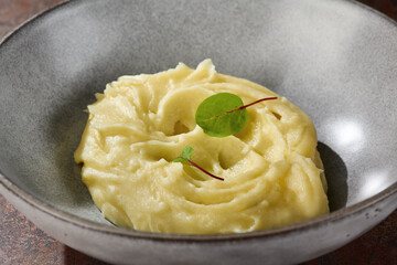 Mashed potatoes with herb garnish, bright lighting, overhead composition in ceramic bowl