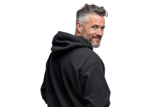 Handsome mature man with gray hair and beard, wearing a black hoodie, looking over his shoulder with a smile