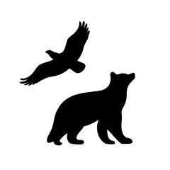 Black silhouette of a bear looking up at an eagle flying above