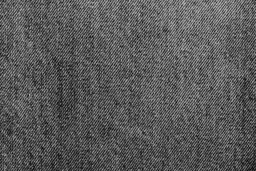 Close-up of black stonewashed denim jeans fabric background backdrop. Traditional fashion garment fabric concept.