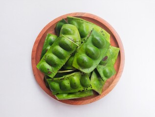 Raw Petai (Parkia Speciosa) or Bitter Bean in a wooden plate on a white background.