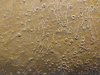 Close-up of a cratered surface marked by pits and ridges. Ideal for sci-fi backgrounds, game textures, planetary visuals, abstract art and graphic design.