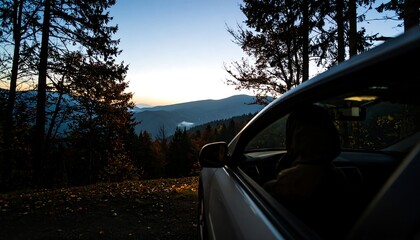 Obraz premium Silhouette of a Car and Driver Overlooking Mountainous Landscape at Dusk