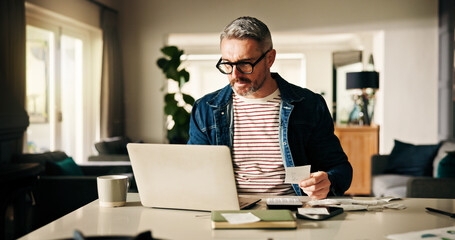 Laptop, receipt and man in home for finance, calculate budget and savings to review expenses. Computer, paper and mature person with bills for payment, bank fee and check account for debt with taxes