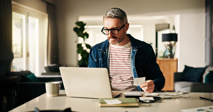 Laptop, receipt and man in home for finance, calculate budget and savings to review expenses. Computer, paper and mature person with bills for payment, bank fee and check account for debt with taxes
