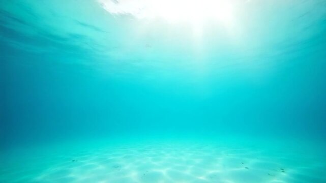 Transparent turquoise ocean with sandy sea bottom and sunlight in Bahamas. Underwater view