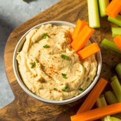 Creamy hummus in a bowl with vegetables