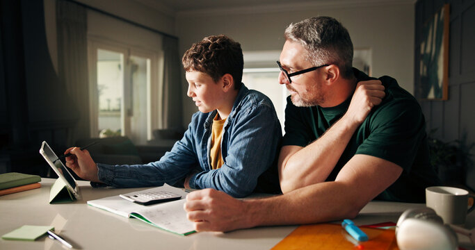 Tablet, homework and help with father and son in kitchen for learning app, education or teaching. Growth, online school schedule and support with man and kid in family home for reading and math tutor