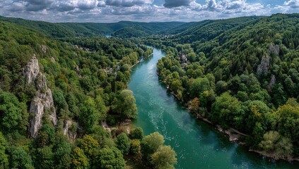 Panoramic view of a river winding through lush green valleys and rocky outcrops
