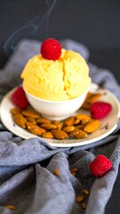 Creamy yellow ice cream with raspberries and almonds
