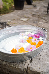 Chrysanthemum flowers and candles on water in a basin.