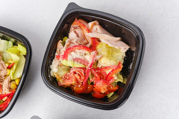 Assorted fresh salads in black containers with gourmet ingredients for meal prep or healthy catering concept