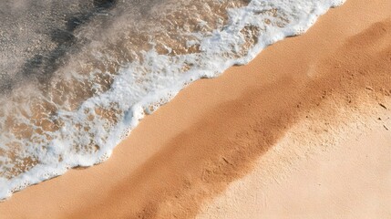 Top view of ocean waves washing onto sandy beach.