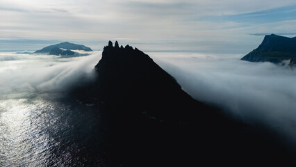Majestic cliffs rise above the fog in the breathtaking Faroe Islands landscape