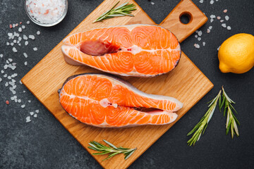 Fresh salmon fillets ready for preparation on a wooden cutting board
