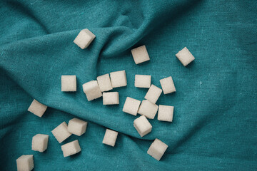 Cubes of sugar scattered on teal fabric during a baking session