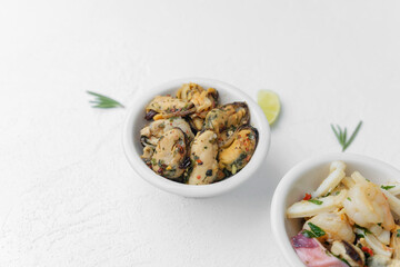Three seafood bowls with herbs and lime on white background for minimal food composition or diet concept