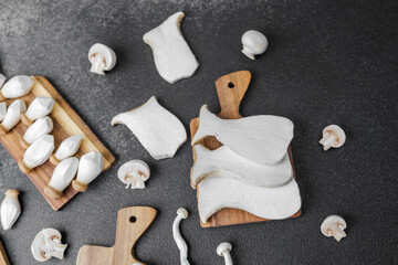 Variety of mushrooms including king oyster, shimeji and button on cutting boards for recip