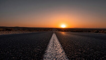 Empty asphalt road stretching into a vibrant sunset