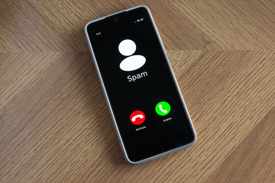 Incoming spam call on mobile phone on table