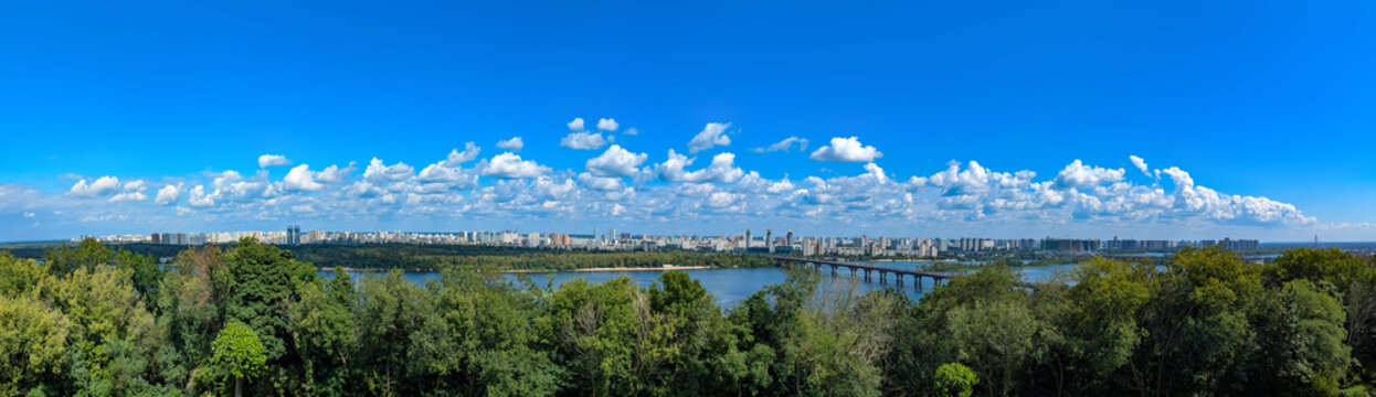 Fototapeta Kiev City - the capital of Ukraine. Kyiv panorama. Paton Bridge, Dnipro river. Riverside. Wine sky view with row of many clouds. White cloud on blue background.